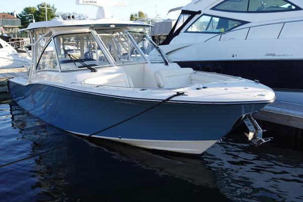 Slide: The Image of 2021 Grady-White Freedom 325 boat docked in marina, featuring sleek design and blue hull. - 0