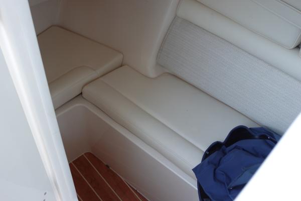 Slide: The Image of 2021 Grady-White Freedom 325 interior cabin with cushioned seating and wooden flooring. - 23