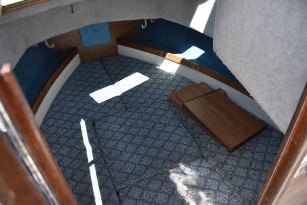 Slide: The Image of 1987 Grady-White Offshore 24 cabin interior with blue patterned carpet and wooden accents. - 49