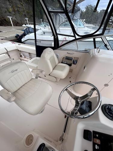 Slide: The Image of 2009 Grady-White Tournament 225 boat cockpit with dual white captain seats and steering wheel. - 5