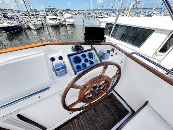 Slide: The Image of 1980 Grand Banks 42 Europa helm with wooden wheel, docked at marina. - 21