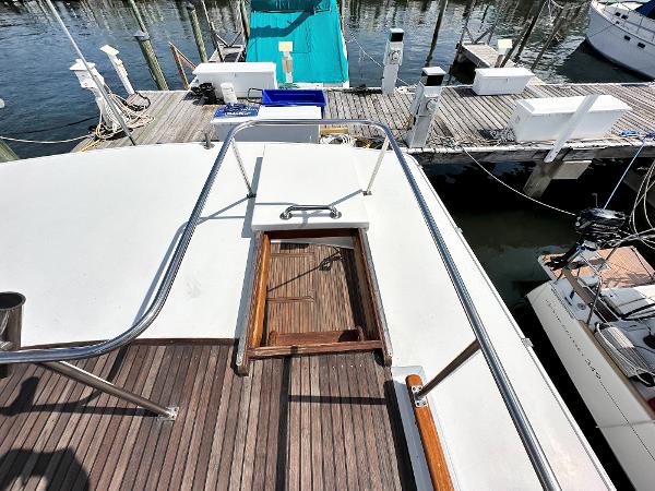 Slide: The Image of 1980 Grand Banks 42 Europa yacht deck with wooden flooring and dock view. - 23