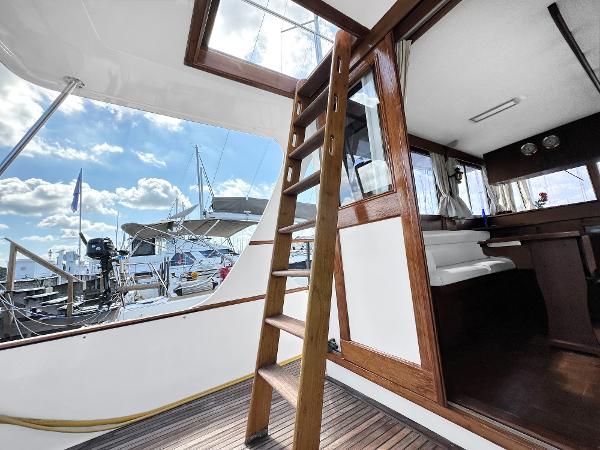 Slide: The Image of Interior view of 1980 Grand Banks 42 Europa yacht with wooden ladder and marina background. - 24