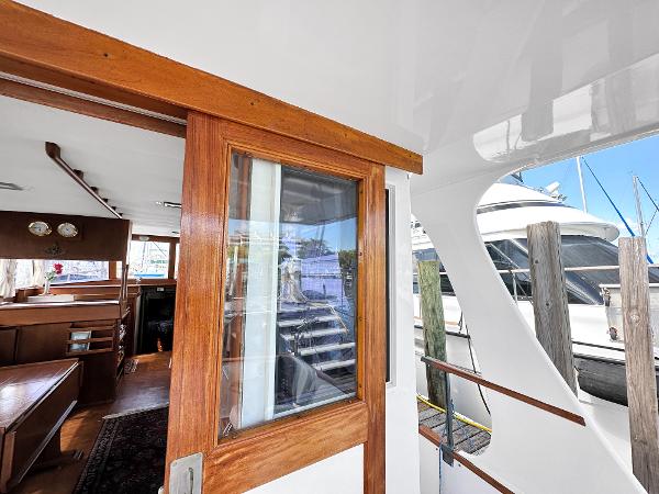 Slide: The Image of 1980 Grand Banks 42 Europa yacht interior with wooden door and marina view. - 26