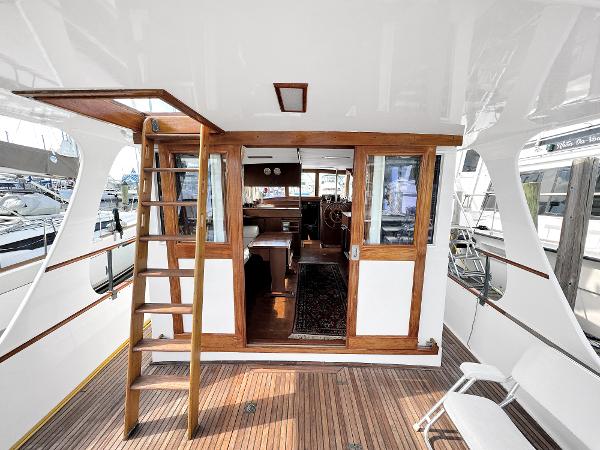 Slide: The Image of 1980 Grand Banks 42 Europa yacht interior with wooden accents and ladder. - 27