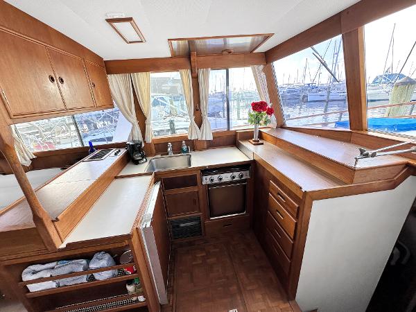 Slide: The Image of 1980 Grand Banks 42 Europa yacht kitchen with wood cabinetry and marina view. - 42