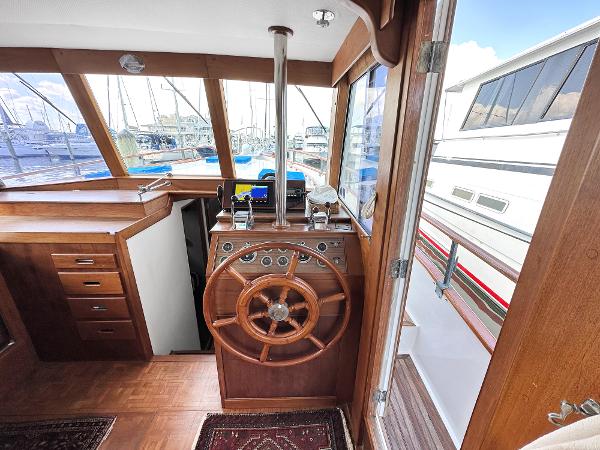 Slide: The Image of Interior helm of 1980 Grand Banks 42 Europa yacht with wooden steering wheel. - 44