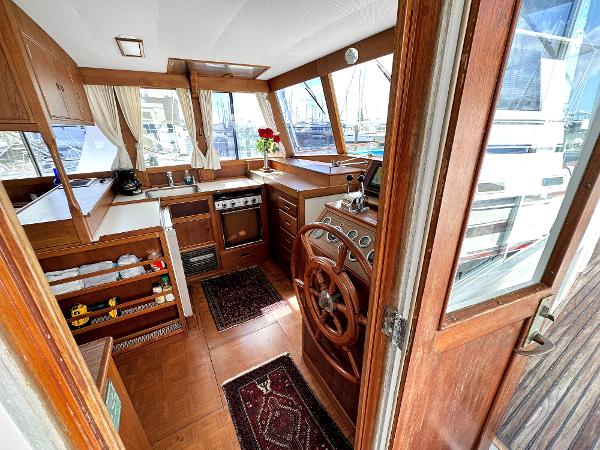 Slide: The Image of Interior of 1980 Grand Banks 42 Europa yacht with wooden helm and kitchen area. - 48