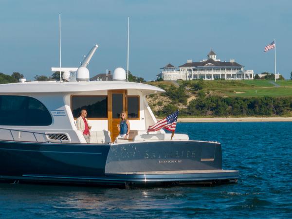 Slide: The Image of Eastbay EB60 yacht cruising near a coastal mansion, 2023 model. - 16
