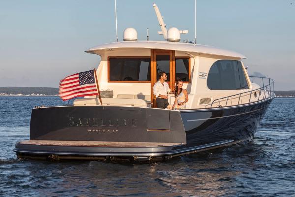 Slide: The Image of Luxurious 2023 Eastbay EB60 yacht cruising with American flag, featuring elegant design and spacious deck. - 27