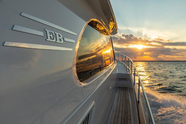 Slide: The Image of Eastbay EB60 yacht cruising at sunset, 2023 model, reflecting golden ocean views. - 4