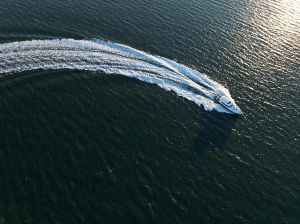 Slide: The Image of Aerial view of 2023 Eastbay EB60 yacht making a sharp turn on open water. - 5