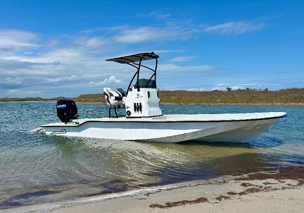 Slide: The Image of 2024 Gulf Coast VariSide boat docked on a sandy shore with clear blue water. - 0