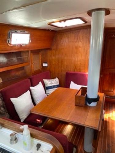 Slide: The Image of 1978 Gulfstar 50 sailboat interior with wooden dining area and red cushioned seating. - 12