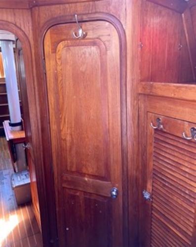 Slide: The Image of 1978 Gulfstar 50 interior wooden cabin door and storage area. - 16