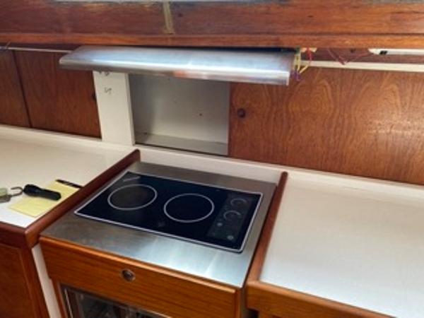 Slide: The Image of 1978 Gulfstar 50 yacht kitchen with electric stovetop and wooden cabinetry. - 31