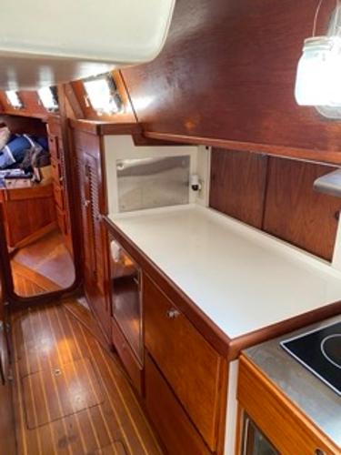 Slide: The Image of 1978 Gulfstar 50 yacht interior galley with wooden cabinetry and white countertops. - 33