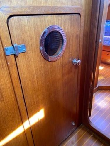 Slide: The Image of 1978 Gulfstar 50 yacht interior with wooden door and porthole. - 37