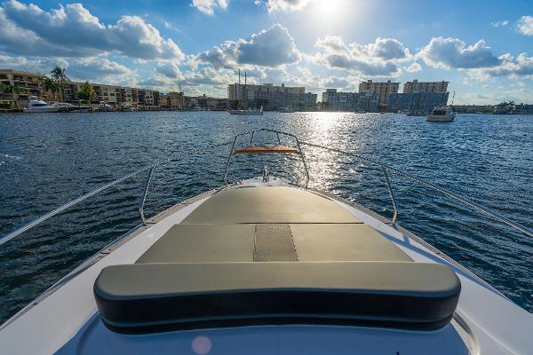 Slide: The Image of Bow view of Hanover 305 boat, 2025 model, cruising on a sunny day with cityscape background. - 1