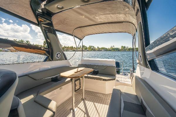 Slide: The Image of Luxurious 2025 Hanover 305 boat interior with seating and table, overlooking serene water. - 5