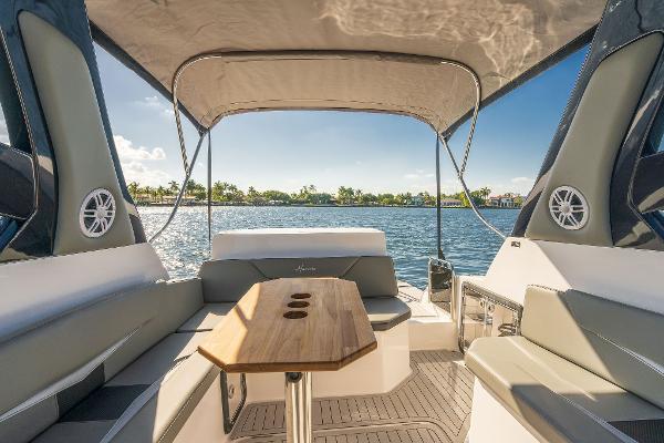 Slide: The Image of 2025 Hanover 305 boat interior with seating, table, and canopy on a sunny day. - 6