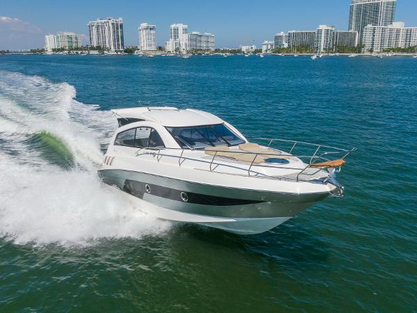 Slide: The Image of 2025 Hanover 375 yacht cruising in sunny coastal waters with city skyline in background. - 2