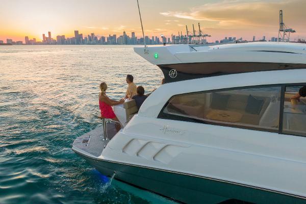 Slide: The Image of 2025 Hanover 375 yacht cruising at sunset with city skyline in background. - 31