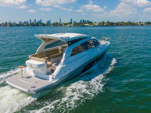 Slide: The Image of 2025 Hanover 375 yacht cruising on blue waters with city skyline in background. - 5