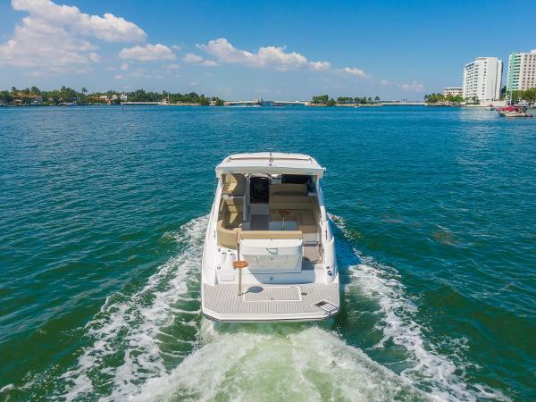 Slide: The Image of 2025 Hanover 375 boat cruising on clear blue water near coastal buildings. - 6