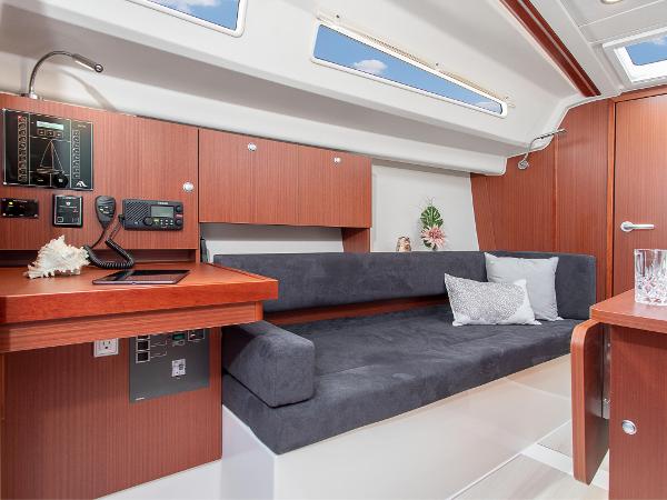 Slide: The Image of 2024 Hanse 315 yacht interior with modern wood cabinetry and plush seating. - 12