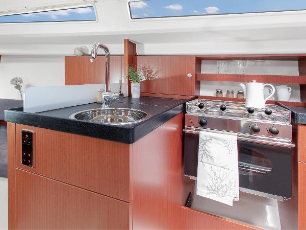 Slide: The Image of Modern kitchen in 2024 Hanse 315 yacht with stove, sink, and wooden cabinetry. - 13