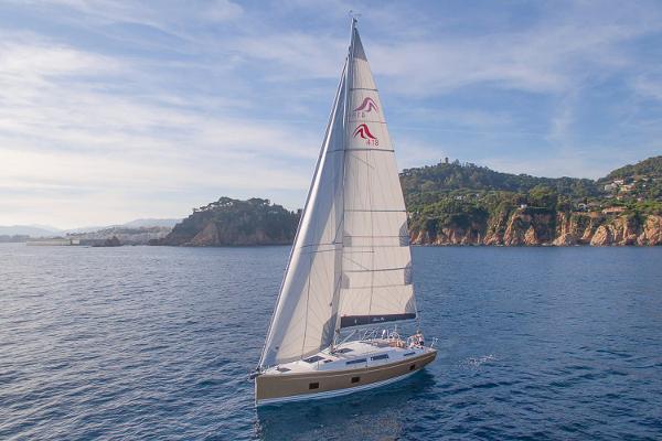 Slide: The Image of 2025 Hanse 418 sailboat cruising near scenic coastline under clear skies. - 0