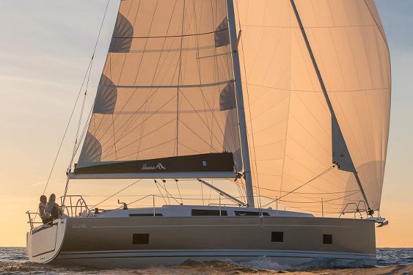 Slide: The Image of 2025 Hanse 418 sailboat cruising at sunset with full sails. - 1