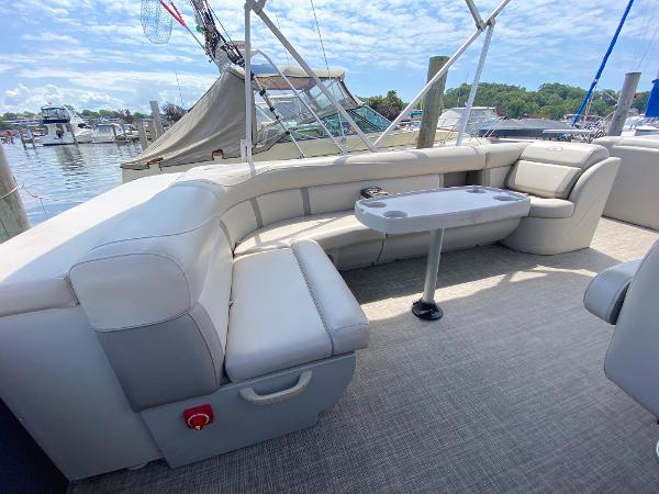 Slide: The Image of 2017 Harris 240 Cruiser boat with spacious seating and table, docked at a marina. - 1
