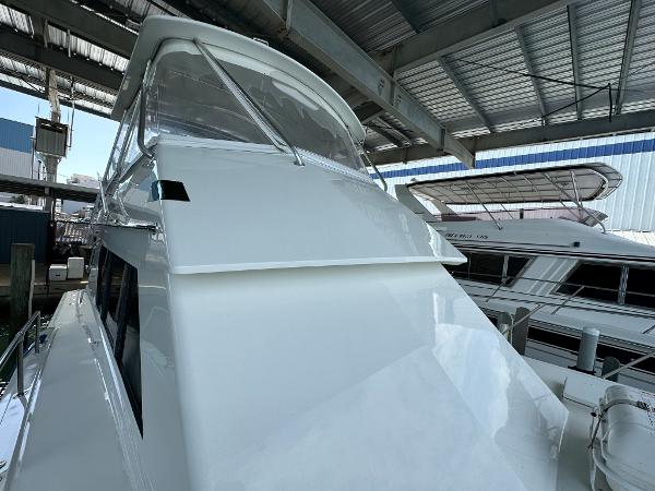 Slide: The Image of 1986 Hatteras 52 Convertible yacht in marina, under a metal roof. - 11