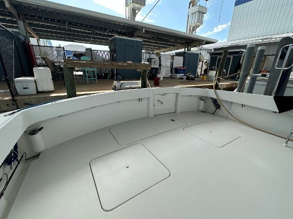 Slide: The Image of 1986 Hatteras 52 Convertible boat deck in a marina setting. - 15
