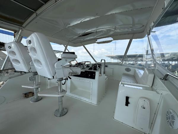 Slide: The Image of Interior helm of 1986 Hatteras 52 Convertible yacht with white seating and controls. - 19