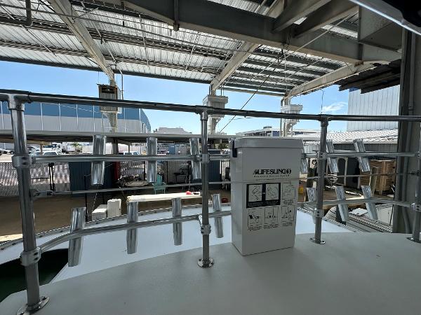Slide: The Image of 1986 Hatteras 52 Convertible boat deck with lifesaving equipment under a metal canopy. - 26