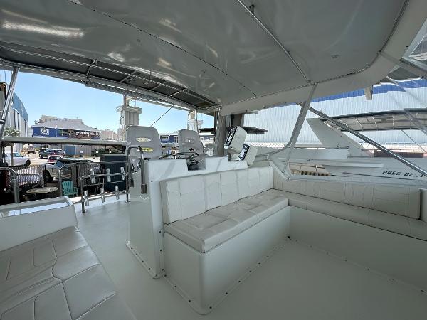Slide: The Image of Interior of 1986 Hatteras 52 Convertible yacht with white seating and helm station. - 27