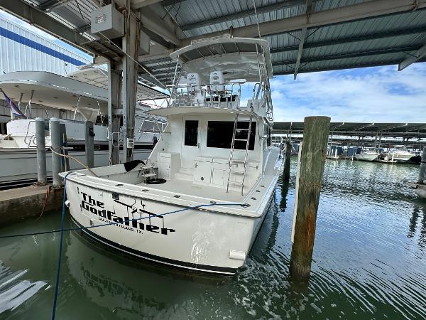 Slide: The Image of 1986 Hatteras 52 Convertible yacht docked in marina under covered shelter. - 3