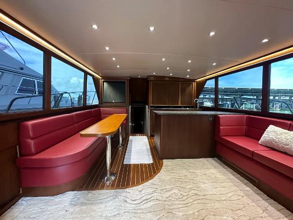 Slide: The Image of Luxurious interior of 1986 Hatteras 52 Convertible yacht with red seating and wood accents. - 31