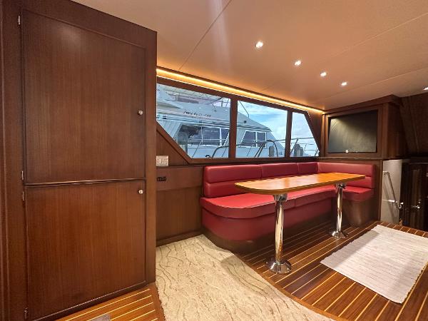 Slide: The Image of Interior of 1986 Hatteras 52 Convertible yacht with red seating and wooden finishes. - 34