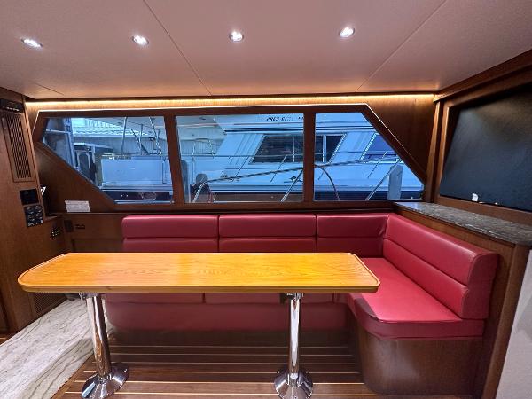 Slide: The Image of Interior of 1986 Hatteras 52 Convertible yacht with red seating and wooden table. - 35