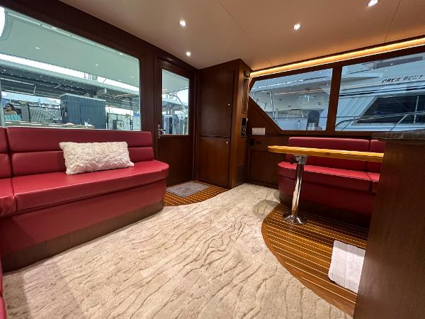 Slide: The Image of Luxurious interior of 1986 Hatteras 52 Convertible yacht with red seating and wood accents. - 36