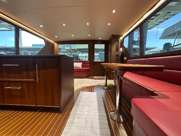 Slide: The Image of Luxurious interior of 1986 Hatteras 52 Convertible yacht with wood finishes and red seating. - 37
