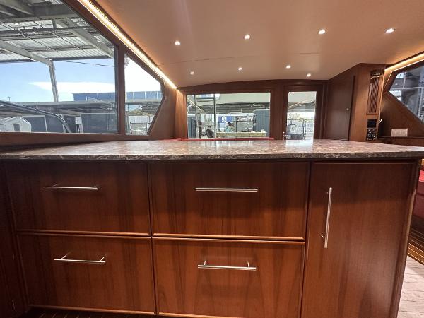 Slide: The Image of Interior of 1986 Hatteras 52 Convertible yacht with wooden cabinetry and marble countertop. - 39