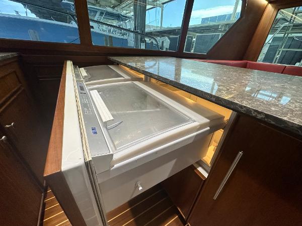 Slide: The Image of 1986 Hatteras 52 Convertible yacht interior with open freezer drawer and marble countertop. - 42