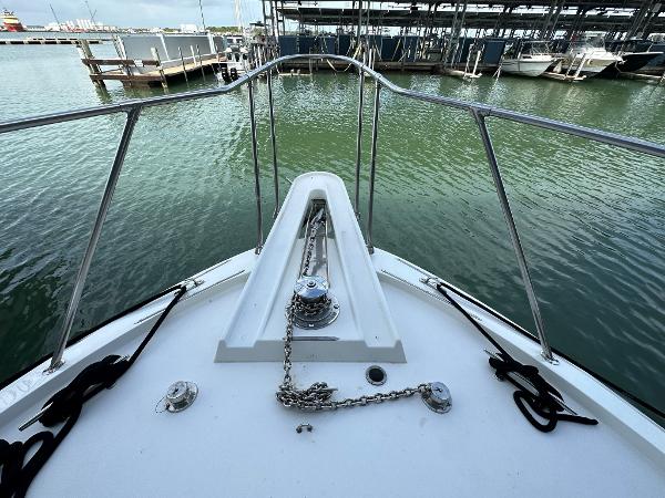 Slide: The Image of 1986 Hatteras 52 Convertible yacht bow with anchor chain, docked in marina. - 9