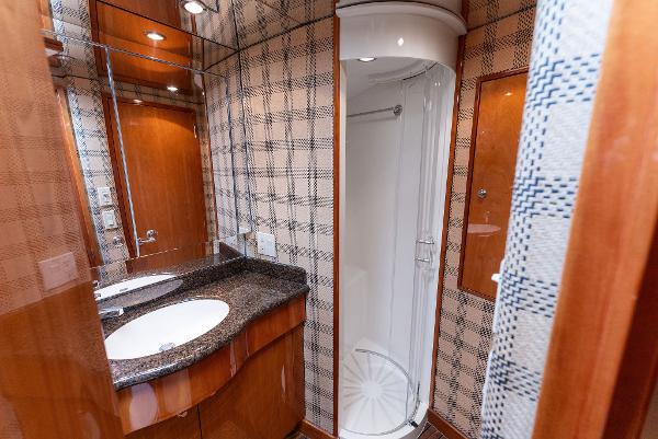 Slide: The Image of 2007 Hatteras 64 Convertible yacht bathroom with shower, sink, and wood accents. - 20