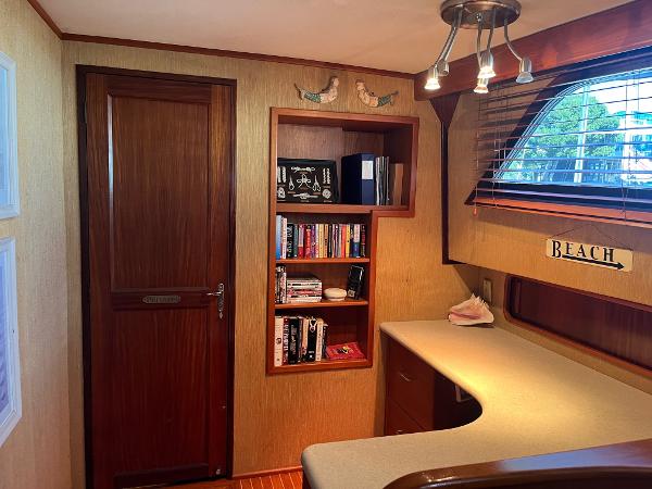 Slide: The Image of 1986 Hatteras 70' Cockpit Motor Yacht interior with bookshelf and desk area. - 10